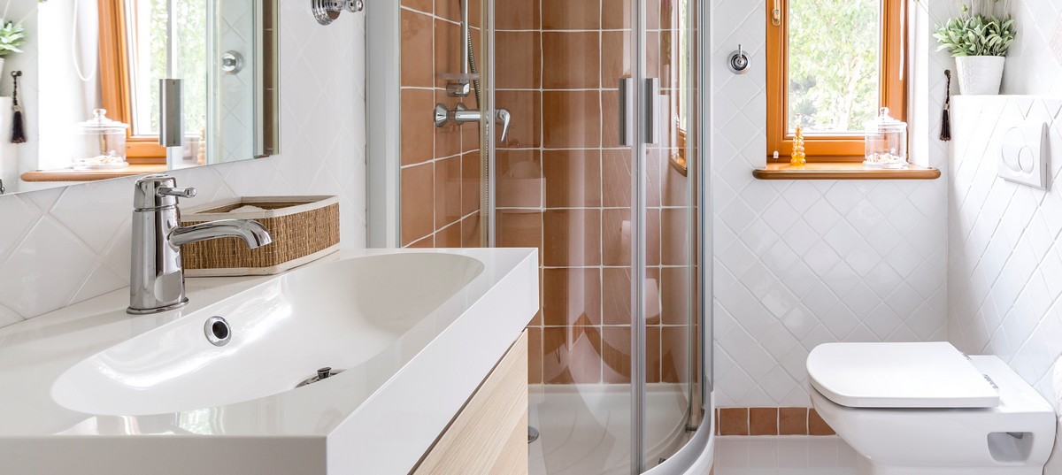 Small but functional bathroom in white with toilet, sink and shower